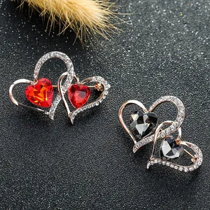 Macro de broches de doble corazón entrelazado con cristallen rojos y negros y pedrería