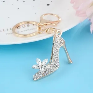 Llavero elegante de tacón alto dorado con cristallen blancos y flor de pedrería