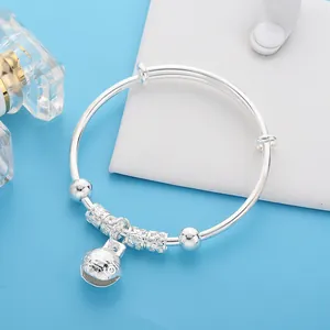 Adjustable silver baby bangle with hollow flower bell charm and textured beads
