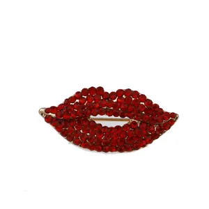 Nahaufnahme einer glitzernden roten Strass-Lippenbrosche mit polierter Goldbasis