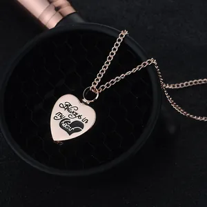 Dettaglio macro del ciondolo a cuore oro rosa con incisione Always in my heart e cuore nero