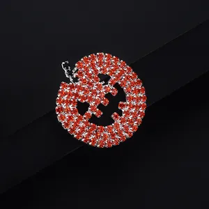 Detail of a Halloween pumpkin brooch with sparkling orange rhinestones and silver metal finish
