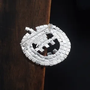 Detailed back view of a silver pumpkin brooch showing the pin clasp and hollow structure