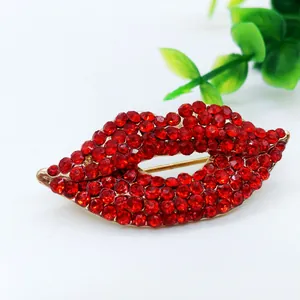 Detailansicht der roten Lippenbrosche mit Strassbesatz und goldfarbenem Verschluss im Detail
