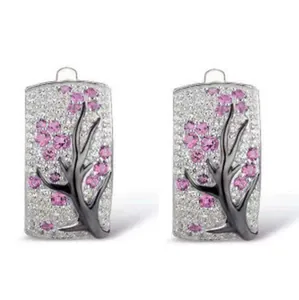 Close-up of silver rectangular hoop earrings with pink flower gems and pavé crystals