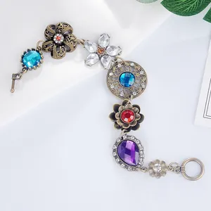 Dettaglio di un bracciale a fiori vintage con cristalli colorati e metallo bronzato