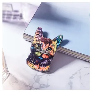 Broche de acrílico con diseño artístico de gato y patrones coloridos sobre mármol