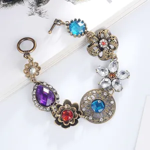 Dettaglio di un bracciale floreale vintage in bronzo con cristalli colorati e chiusura a T