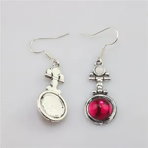Detail view of vintage silver earrings featuring purple resin gemstones and white beads