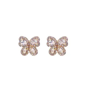 Golden butterfly stud earrings with sparkling teardrop-shaped zircons on white background
