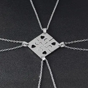 Vierteiliges silbernes Puzzle-Herz-Halsketten-Set für beste Freunde auf grauem Hintergrund