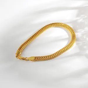Detail eines goldenen Fuchsschwanz-Kettenarmbands mit flach gewebter Textur und Karabiner