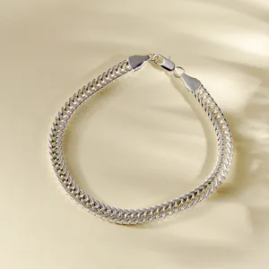 Klassisches Silber-Fuchsschwanzarmband mit Karabinerverschluss auf warmem beigem Hintergrund