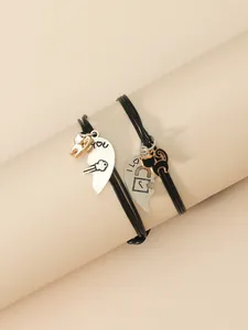 Detalle de colgantes de gato con grabado en pulseras trenzadas para parejas