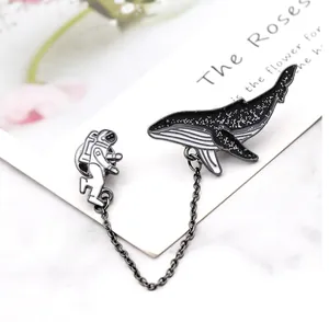 Ensemble broche astronaute et baleine avec chaîne et paillettes cosmiques sur fond marbre