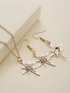 Close-up of gold-plated starburst jewelry set featuring sparkling rhinestones