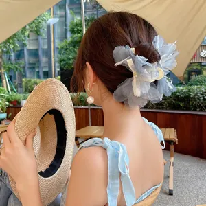 Pinza de pelo de flor de gasa azul claro con detalle de cinta blanca y pendientes perla