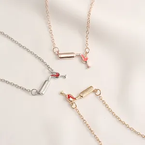 Detailansicht von drei Halsketten mit Weinflasche und Glas in Gold, Silber und Rosé