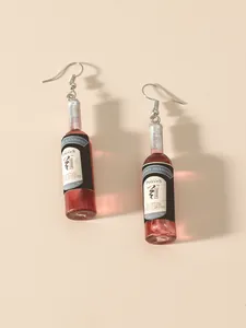 Detail of miniature red wine bottle earrings with crystal accents and realistic wine labels