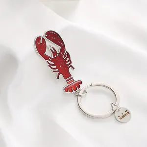 Roter Emaille-Hummer-Schlüsselanhänger mit U R MY LOBSTER Gravur auf weißem Satin