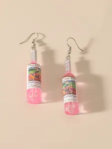 Close-up of creative pink wine bottle earrings with silver glitter and retro labels