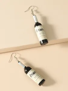 Macro shot of miniature red wine bottle earrings with vintage labels and silver foil details