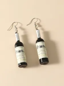 Detailed view of miniature wine bottle earrings with French label on beige background