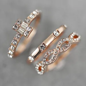 Three-piece rose gold ring set featuring cross and infinity designs with zircon stones