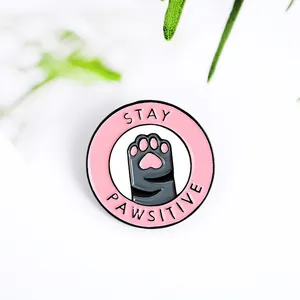 Broche en émail chat rose mignon avec citation Stay Pawsitive sur fond blanc