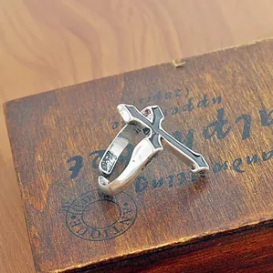Macro shot of vintage silver cross ring with black enamel on a rustic wooden box