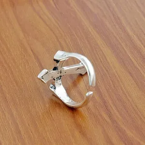 Detail of adjustable cross ring with vintage matte silver finish on wood surface