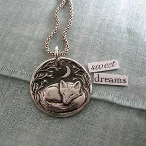 Artistic moon and sleeping fox pendant necklace with a vintage silver relief design