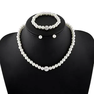 Three-piece pearl jewelry set with sparkling pavé crystal balls on a black neck bust