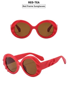 Detailansicht der roten ovalen Sonnenbrille mit Reliefrahmen und teefarbenen Gläsern