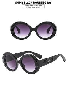 Makroansicht der ovalen Sonnenbrille mit schwarzem Rahmen und grauen Verlaufsgläsern