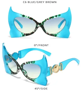 Dettaglio di occhiali da sole cat eye blu con accenti dorati e lenti sfumate