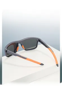 Close-up of sports sunglasses with matte grey frame and bright orange non-slip nose pads