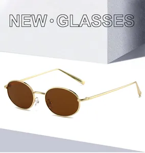 Side view of retro oval sunglasses with a gold metal frame and dark brown lenses