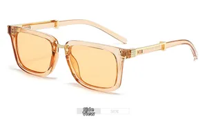 Detailed side view of amber square sunglasses with golden metal hinges and textured temples
