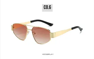 Détail de lunettes de soleil à double pont en métal doré avec verres dégradés orange