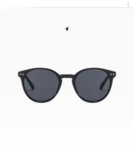 Detailed view of black round vintage sunglasses featuring silver rivet accents on frame