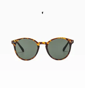 Detail view of retro round sunglasses featuring a classic tortoise shell pattern and metal rivets