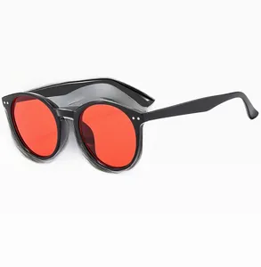 Detail view of vintage round sunglasses with black plastic frames and red tinted lenses