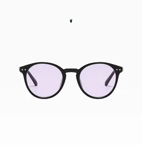 Detail view of round vintage sunglasses featuring bright black frames and purple lenses