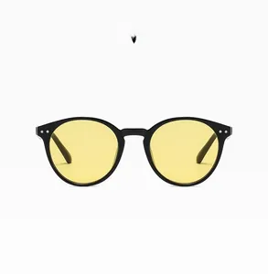 Detail view of round vintage black frame sunglasses with vibrant yellow translucent lenses