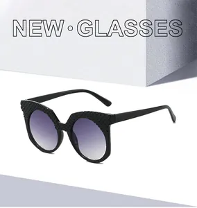 Détail de lunettes de soleil œil de chat noires avec monture texturée et verres dégradés