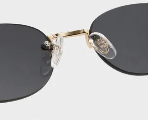 Detail of golden metal bridge and soft silicone nose pads on rimless sunglasses