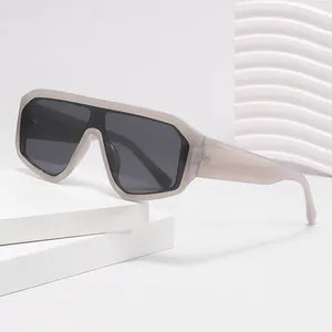 Lunettes de soleil bouclier futuristes avec monture grise sur podium géométrique