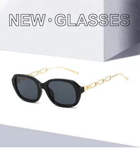 Détail de lunettes de soleil carrées noires avec d'élégantes branches en chaîne dorée