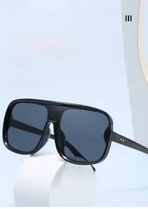 Detail of oversized flat top sunglasses with dark lenses and gold temple accents